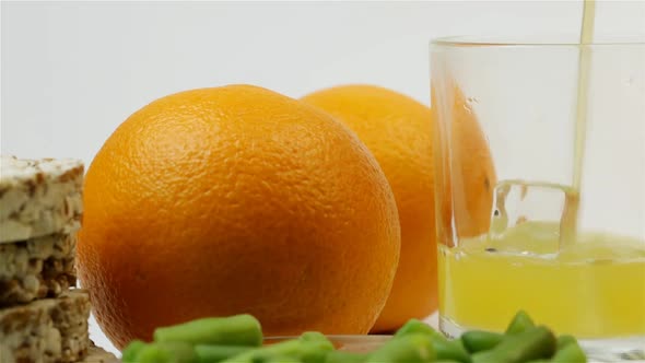 Two Oranges, Bread Rolls And Green Beans With Orange Juice On A White Background