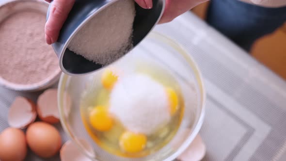 Dough Preparation  Woman Cook Pours Sugar to Glass Bowl with Crushed Eggs alt