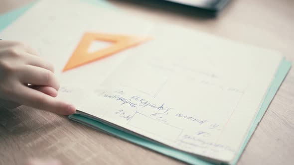 CU: Boy Sit in Headphones and Do School Homework, Flips Through the Page in the Notebook alt