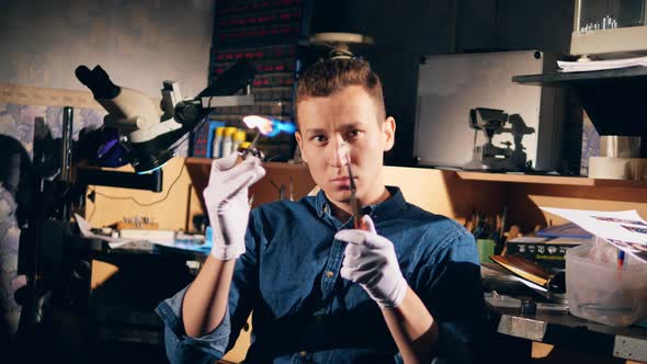 A Ring Is Getting Burnt By a Male Jeweler alt