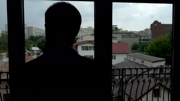 Businessman in Silhouette Walking in His Office at the Big Windows alt