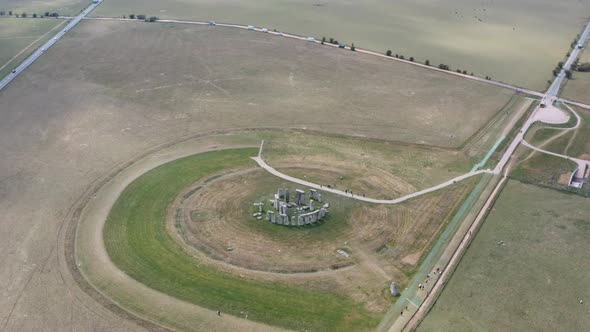 Cinematic dolly forward pan down aerial drone shot of Stonehenge UK alt