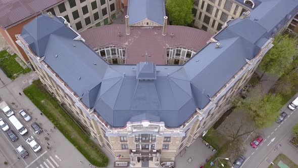 Drone footage panning out a unique and symmetrical rectangular medieval building in the city of Cluj alt