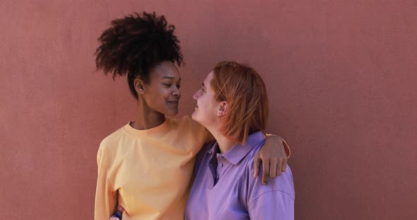 Multiracial lesbian couple holding hands and having tender moment together alt