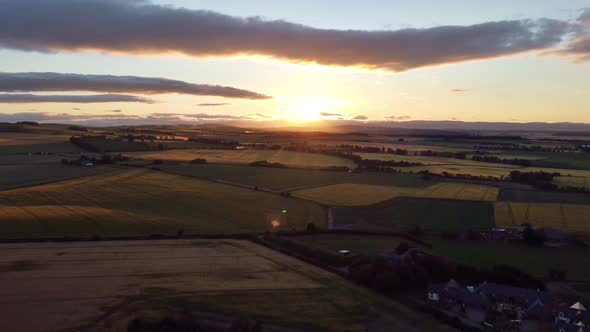 Shooting From a Drone of a Sunset with Green Fields
