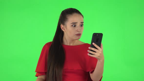 Portrait of Pretty Young Woman Is Angrily Talking for Video Chat Using Mobile Phone. Green Screen alt