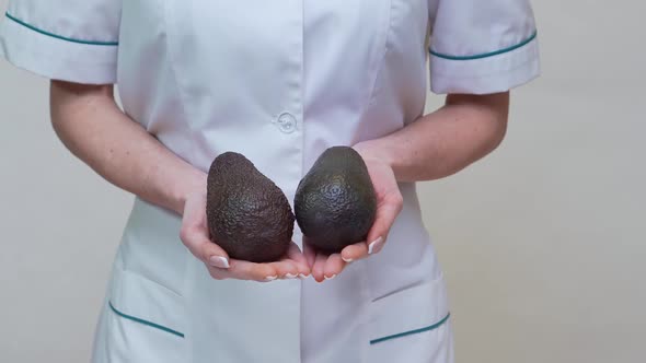 Nutritionist Doctor Healthy Lifestyle Concept - Holding Organic Avocado alt