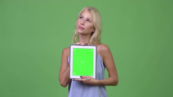 Young Happy Beautiful Businesswoman Thinking While Showing Digital Tablet