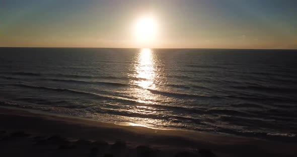 Aerial drone shot of the beach at sunset on Captiva Island, Florida. Slow wide pan to the left. alt