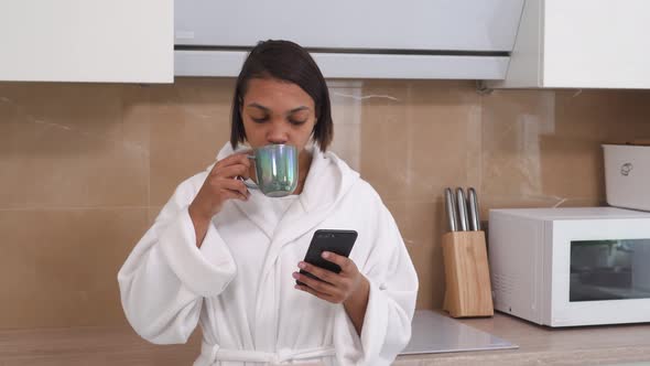 A Woman is Drinking Coffee and Browsing Social Networks on Her Smartphone