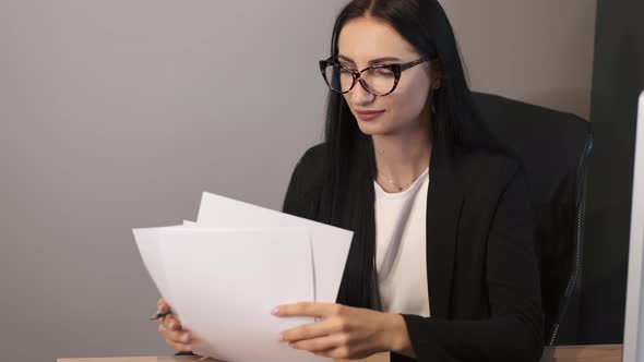 Brunetter Business Woman Working at the Office with Papers alt