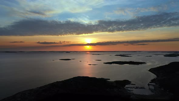 Aerial beautiful sunset with vivid and cinematic colours at a rocky coastline with islands. alt