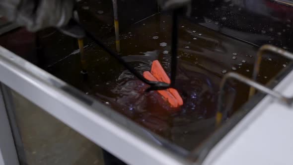 Heat Treatment Shop. Hot Metal Part in Special Tongs alt