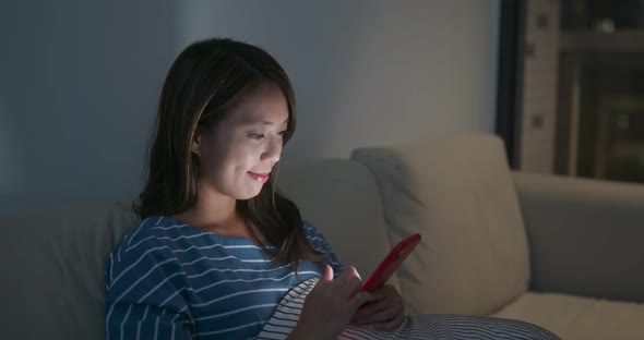 Woman use of smart phone at home in the evening alt