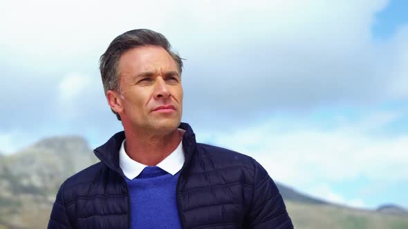 Mature man standing on beach alt