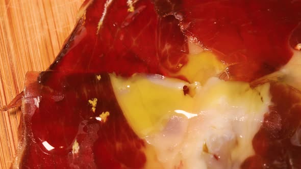 Olive oil poured on high quality serrano ham, macro shot. Close up view from above. alt