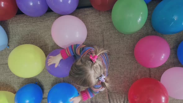 Small Funny Girl is Playing with Colorful Balloons