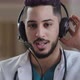 Web Camera View Young Male Hispanic Doctor Practitioner Arab Man Wear Headphones with Microphone