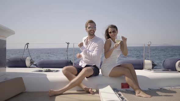 Rich Young Couple Dancing on Yacht Seated