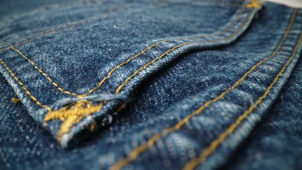Extreme detailed of blue denim jeans texture in dolly shot over cloth surface. alt