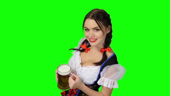 Girl in Bavarian Costume Offers a Glass of Beer. Green Screen alt