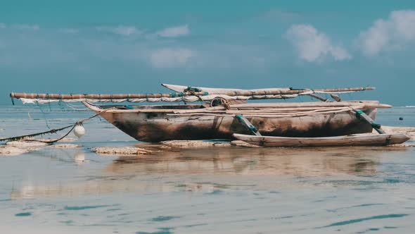 African Traditional Wooden Boat Stranded in Sand on Beach at Low Tide Zanzibar alt