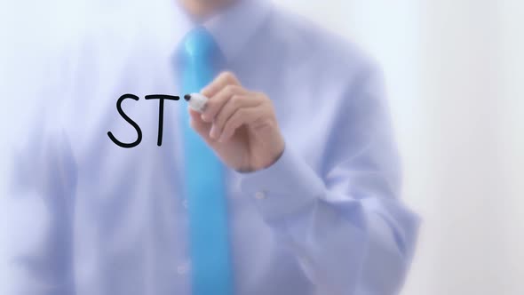 Strategy Written on Glass. Businessman Hand Writing Words with Marker Pen