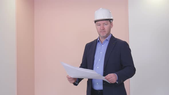 Portrait Of A Successful Builder In A White Helmet And Business Suit