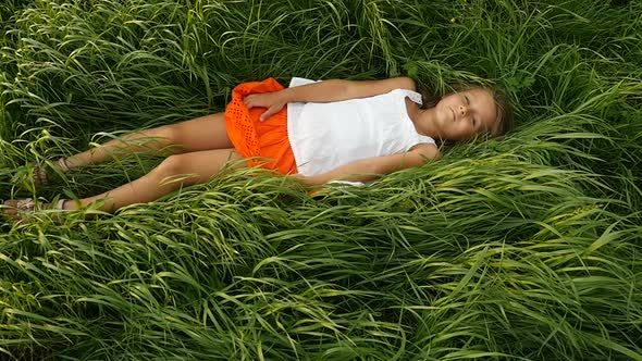 Little Girls Resting on the Green Grass. Beautiful Kids Lying on the Field
