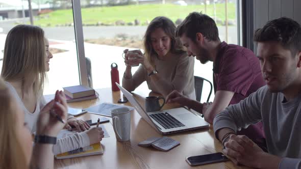 Group of young business people working together in casual workspace