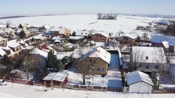 Aerial Drone Shot  Snowcovered Houses in a Village in Winter  Drone Turns to the Right alt