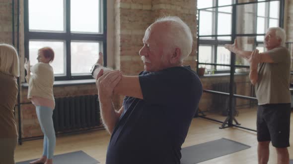 Mature People Stretching Arms in Class alt