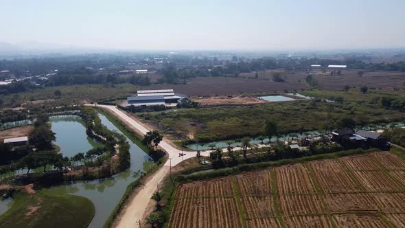Aerial of Polluted Farmlands and Canal near the Mountains alt