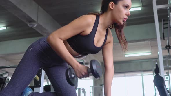 Woman lifting dumbbell in a fitness