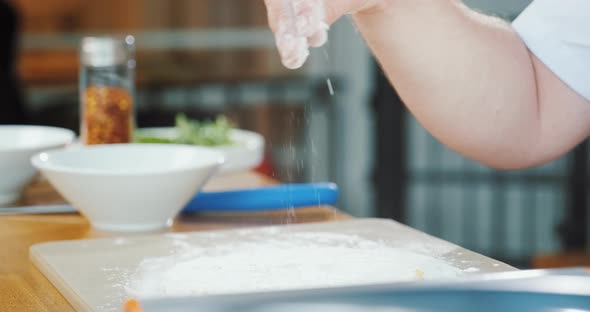 Hand of Chef Sprinkling Flour in Kitchen Chef Cooking Dough in Restaurant