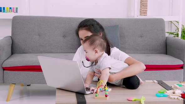 Kid plays with his mother working from home. Happy family at home mommy baby