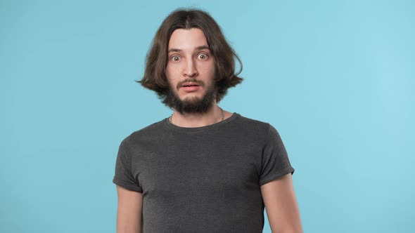 Portrait of Caucasian Brunette Man Bulging Eyes and Covering Mouth in Fright Reacting on Awful alt