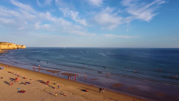 Aerial drone view of people on the beach during a beautiful sunset. Amazing vibrant colors