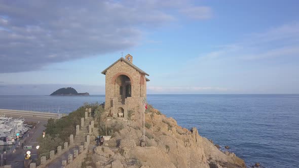 Aerial view of chapel in Alassio, Liguria, Italy. Revealing Gallinara island alt