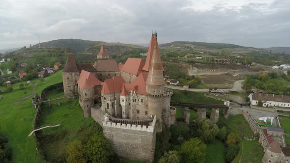 Aerial view of Corvin Castle surrounded by a greenland alt