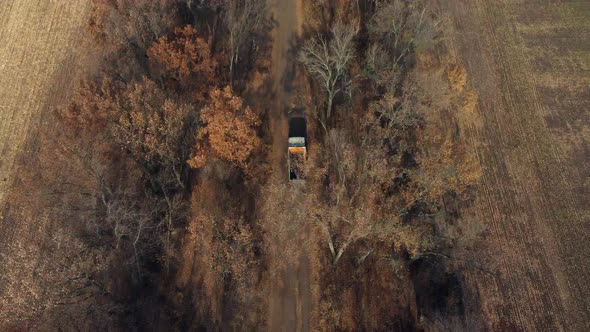 Aerial Drone View Flight Over Truck with an Empty Body Driving Along Dirt Road alt