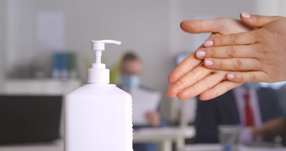Cropped Shot of Female Office Worker Using Antibacterial Antiseptic Gel for Hands Disinfection alt