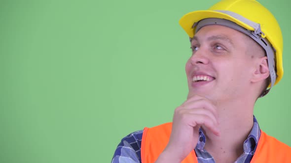 Face of Happy Young Man Construction Worker Thinking and Looking Up alt