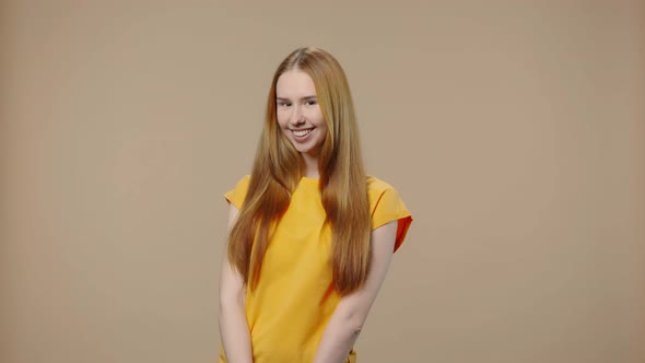 Portrait of Model with Natural Beauty Coquettishly Waves Hello Makes Gesture to Come Here alt