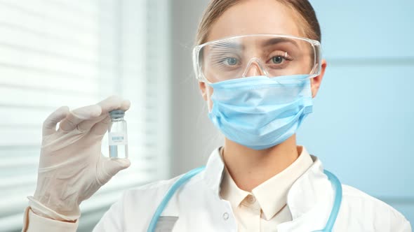 Young woman researcher in blue disposable mask glasses alt
