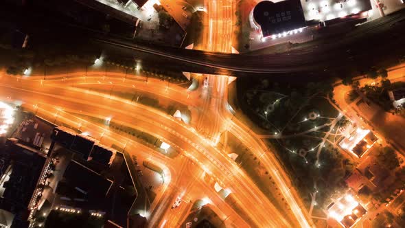Aerial Zoom Out Illuminated Highway Crossroad Top View Car Light Trails at Night, Drone Hyper Lapse alt
