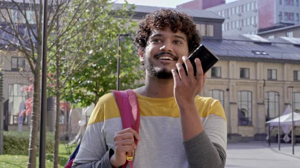 Young man walking at the street, positive talking.