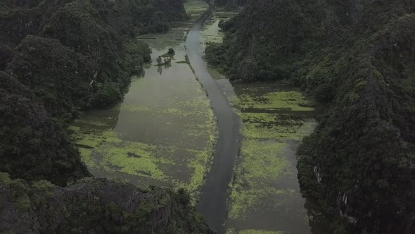 Large Swampy River Runs Between Ancient Rocky Mountains in Ninh Binh Vietnam