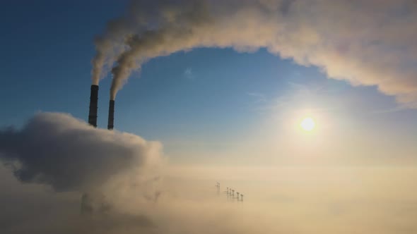 Aerial view of coal power plant high pipes with black smoke moving up polluting atmosphere alt