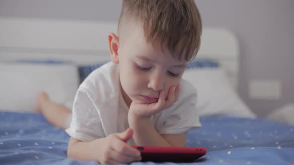 Cute Little Boy Preschool Child Using a Phone or Digital Tablet Technology Device Looks Telephone alt